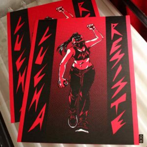 Serigrafia Ague La imagen que me enviaste muestra una figura humana en un estilo artistico, rodeada de palabras en un fondo rojo. La figura esta en el centro, mostrada en una pose fuerte y empoderada, llevando ropa oscura y con el puno levantado. Las palabras grandes a los lados de la figura dicen "LUCHA" y "RESISTE". El fondo es rojo con detalles negros que anaden contraste a la imagen. La imagen tiene un esquema de color rojo y negro predominante.